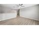 Open loft featuring wood-look floors, neutral paint, and ceiling fan for comfort at 12534 Chenwood Ave, Hudson, FL 34669