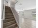 Staircase with wood stairs leads to the open-concept living area with lots of natural light at 12534 Chenwood Ave, Hudson, FL 34669