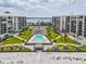 Aerial view of condo buildings with a swimming pool, tiki huts, and beach access at 1400 Gulf Blvd # 701, Clearwater Beach, FL 33767