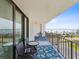 Balcony with outdoor seating and a view of the water, palm trees, and clear blue skies at 1400 Gulf Blvd # 701, Clearwater Beach, FL 33767