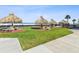 Lush grassy common area with tiki huts, tables, and beach access at 1400 Gulf Blvd # 701, Clearwater Beach, FL 33767
