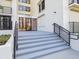 Entrance to white condo building featuring stairs, railing, and glass doors at 1400 Gulf Blvd # 701, Clearwater Beach, FL 33767