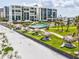 Exterior shot of a condo building with a pool, tiki huts, and beach access at 1400 Gulf Blvd # 701, Clearwater Beach, FL 33767