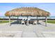 Thatched tiki hut with tables and chairs, perfect for beachfront dining and relaxation at 1400 Gulf Blvd # 701, Clearwater Beach, FL 33767