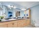 Bathroom with double sinks, blue countertops, bright lighting, and a glass-enclosed shower at 401 Sunset Dr, Venice, FL 34285