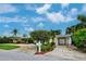 Exterior view showcasing the property with well-manicured lawn, colorful foliage, and yellow facade at 401 Sunset Dr, Venice, FL 34285