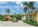 Charming home with lush landscaping, palm trees, and a beautiful fountain in the front yard at 401 Sunset Dr, Venice, FL 34285