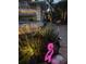 A lush garden, a water fountain, and a flamingo lawn ornament create a beautiful scene at dusk at 401 Sunset Dr, Venice, FL 34285