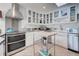 Bright kitchen features stainless appliances, glass-front cabinets, and tiled backsplash at 401 Sunset Dr, Venice, FL 34285