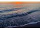 View of an ocean sunset with gentle ocean waves crashing on the sandy shoreline at 401 Sunset Dr, Venice, FL 34285