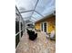 Relax on the screened patio featuring neutral stone floors and a beautiful mustard-colored home exterior at 401 Sunset Dr, Venice, FL 34285