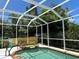 This is a beautiful backyard pool with a spa surrounded by mature landscaping and under a screened enclosure at 401 Sunset Dr, Venice, FL 34285