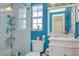 Blue bathroom with a toilet and shower features lots of decor and storage space at 16601 W Course Dr, Tampa, FL 33624