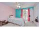 Pink and turquoise bedroom features a ceiling fan and french doors to a balcony at 16601 W Course Dr, Tampa, FL 33624