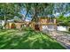 Two-story home with a well-manicured lawn, mature trees, and brick driveway at 16601 W Course Dr, Tampa, FL 33624