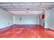 Spacious garage with red flooring, water heater, and plenty of open space at 16601 W Course Dr, Tampa, FL 33624