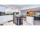 Open concept kitchen with island, white cabinets, stainless appliances, and a breakfast bar at 16601 W Course Dr, Tampa, FL 33624