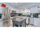 Modern kitchen showcasing stainless steel appliances, a center island, and white cabinetry at 16601 W Course Dr, Tampa, FL 33624