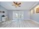 Spacious living room with wood-look flooring and glass French doors to backyard at 16601 W Course Dr, Tampa, FL 33624