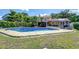 A spacious backyard featuring a sparkling pool, brick patio, and mature trees, providing a private and serene oasis at 16601 W Course Dr, Tampa, FL 33624