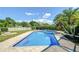 Beautiful pool with blue tile and brick border, surrounded by lush landscaping and serene backyard views, perfect for relaxation at 16601 W Course Dr, Tampa, FL 33624