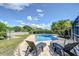 Serene pool area with lounge chairs, framed by lush landscaping and a charming white picket fence, perfect for outdoor relaxation at 16601 W Course Dr, Tampa, FL 33624