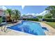An inviting pool surrounded by a brick patio and lush greenery, creating a perfect space for relaxation and recreation at 16601 W Course Dr, Tampa, FL 33624