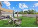 A backyard with green grass and outdoor seating underneath a sun shade canopy at 3270 Rock Sound St, Bradenton, FL 34208