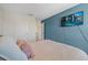 Modern bedroom with a flat-screen TV, soothing blue accent wall, and comfortable bed, perfect for unwinding at 3270 Rock Sound St, Bradenton, FL 34208