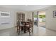 Bright dining area with a wooden table, four chairs, cabinet, and sliding glass door to backyard at 3270 Rock Sound St, Bradenton, FL 34208