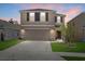 Inviting two-story home with a spacious driveway, attached garage, well-maintained lawn, and decorative landscaping at sunset at 3270 Rock Sound St, Bradenton, FL 34208