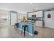Bright kitchen featuring an island with seating, white cabinetry, stainless steel appliances, and a pantry at 3270 Rock Sound St, Bradenton, FL 34208