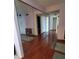 Hallway featuring wood flooring, a mirrored wall, and access to multiple rooms at 632 Edgewater Dr # 832, Dunedin, FL 34698