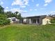 Spacious backyard featuring lush green grass, screened in lanai and views of mature trees at 5136 Cedar Hammock Dr, Sarasota, FL 34232
