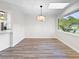 Bright dining area with wood flooring, modern light fixture, and a large window offering views of the outdoors at 5136 Cedar Hammock Dr, Sarasota, FL 34232