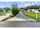 Wide driveway approaching a well-maintained home with green lawns and mailbox at 5136 Cedar Hammock Dr, Sarasota, FL 34232
