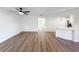 Expansive living room featuring a modern ceiling fan, wood floors, and an open layout to the kitchen area at 5136 Cedar Hammock Dr, Sarasota, FL 34232