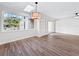 Bright living room boasts wood floors, skylight, view of the front yard, and sliding door to enclosed patio at 5136 Cedar Hammock Dr, Sarasota, FL 34232