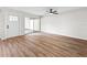 Bright living room features wood floors, a ceiling fan, and sliding door to an enclosed patio at 5136 Cedar Hammock Dr, Sarasota, FL 34232