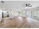 Bright open-concept living room with wood flooring, ceiling fan, and sliding glass doors leading to outdoor at 5136 Cedar Hammock Dr, Sarasota, FL 34232