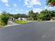 Neighborhood street with a view of a landscaped house, mature trees and a mailbox at 5136 Cedar Hammock Dr, Sarasota, FL 34232