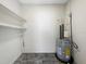Utility room with water heater and utility sink, featuring shelving for storage at 5136 Cedar Hammock Dr, Sarasota, FL 34232