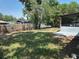 Spacious backyard with green grass, a wood fence, and mature trees at 7169 Holiday Dr, Spring Hill, FL 34606