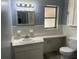 This bathroom features an undermount sink, a built-in vanity and medicine cabinet lighting at 7169 Holiday Dr, Spring Hill, FL 34606