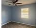 This bedroom features light blue walls, wood-look flooring and a ceiling fan at 7169 Holiday Dr, Spring Hill, FL 34606