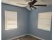 This bedroom has light blue walls, wood-look flooring and two windows at 7169 Holiday Dr, Spring Hill, FL 34606
