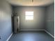 Bonus room with updated gray paint, a window for natural light, and painted flooring at 7169 Holiday Dr, Spring Hill, FL 34606