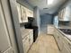 Eat-in kitchen with white cabinets, stone countertops, black appliances, and tile flooring at 7169 Holiday Dr, Spring Hill, FL 34606