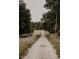 A long gravel driveway lined with trees, leading to the property in a serene setting at 18142 Powerline Rd, Dade City, FL 33523
