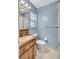 Light blue bathroom featuring a wood vanity, white toilet, and a large mirror at 6443 34Th N Ave, St Petersburg, FL 33710